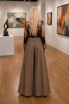 Back view of Apricot brown wide leg tailored trousers showing the flowing full-length silhouette.